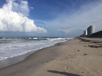 A beach with footprints in the sand and a building in the background